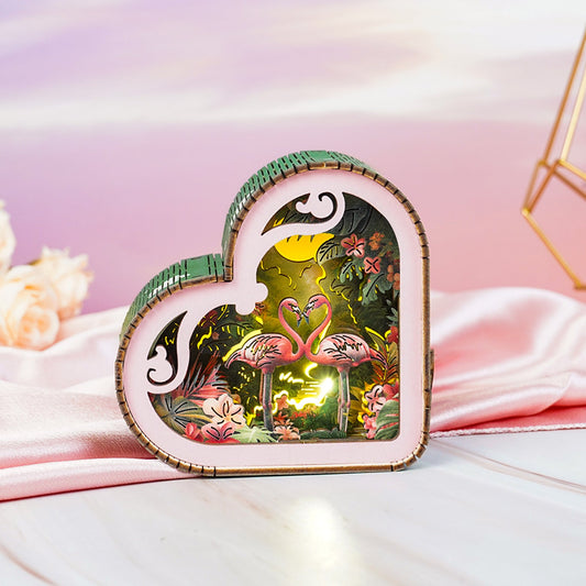 Heart-shaped 3D wooden puzzle night light featuring flamingos and a vibrant forest scene.