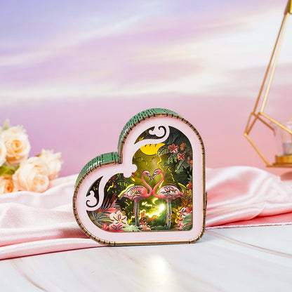Flamingo with moonlight forest design 3D wooden puzzle night light, heart-shaped and vibrant, set against soft pastel background.