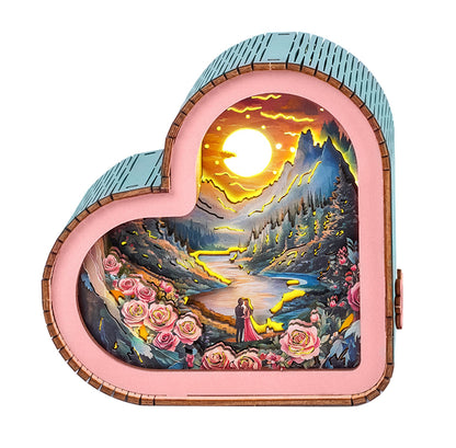 Heart-shaped 3D wooden puzzle night light featuring a romantic sunset scene with roses and lovers by a river.