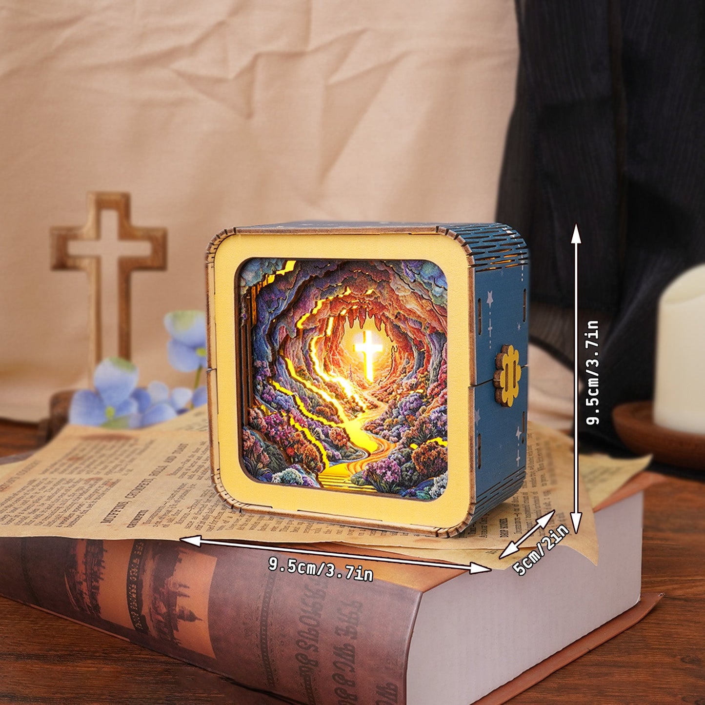 Dazzling Cross Kit 3D wooden puzzle night light illuminating a cave with a cross, displayed on a book.
