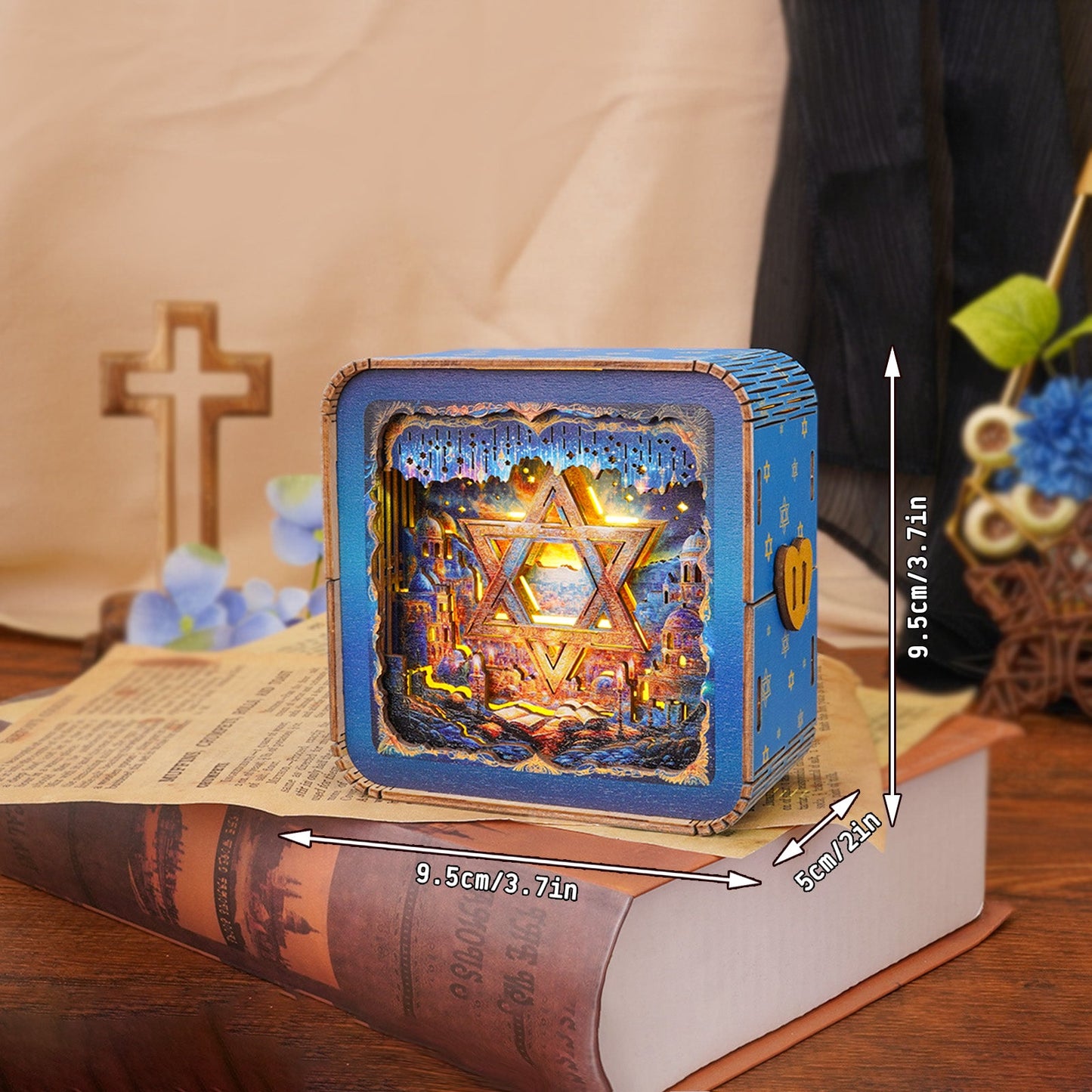 3D wooden puzzle night light shaped like Star of David, displayed on a book with a cross and flowers in the background.